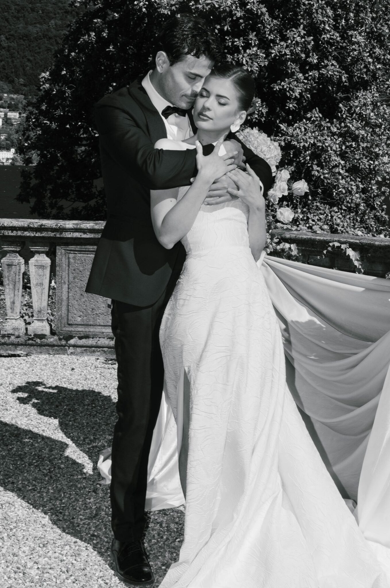 Bride and groom in black and white in a close embrace on the terrace of a villa on Lake Como