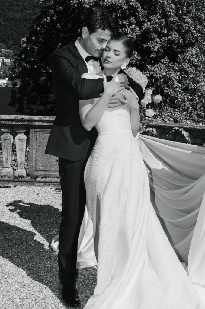 Bride and groom in black and white in a close embrace on the terrace of a villa on Lake Como