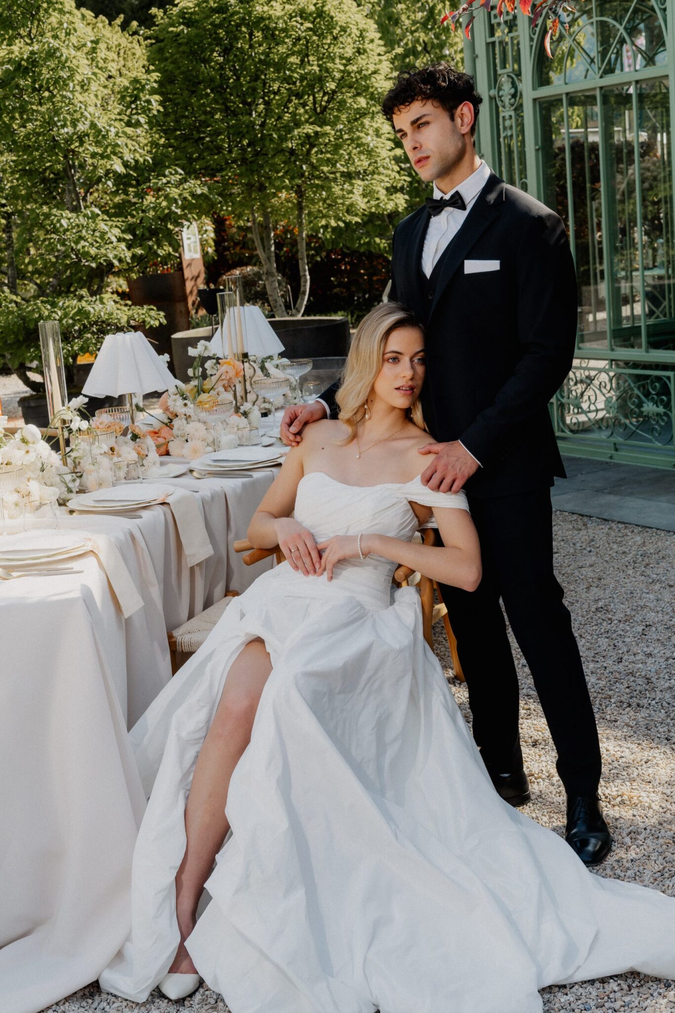 Wedding couple at the wedding table in front of a glass pavilion in Switzerland