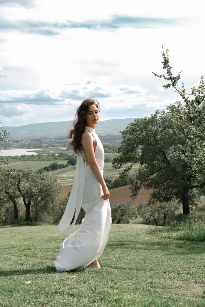 Bride in a flowing dress in the hilly landscape of Tuscany